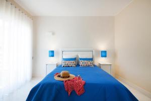 a bedroom with a blue bed with a hat on it at Litoral Mar Beside the Beach in Portimão