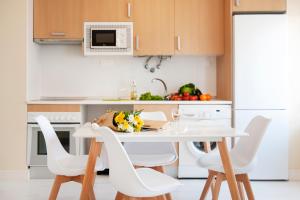 a kitchen with a white table and white chairs at Litoral Mar Beside the Beach in Portimão