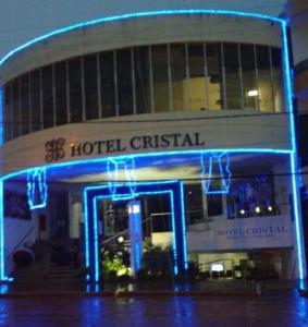 a hotel with blue lights in front of a building at Hotel Cristal in Turmalina