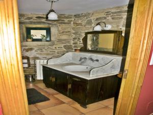a bathroom with a sink and a stone wall at Casa Refugio de Verdes in Verdes +33 photos