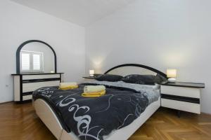 a bedroom with a bed with a black and white comforter at Barun apartments Kastela in Kaštela