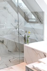 a bathroom with a glass shower and a sink at The Guesthouse Vienna in Vienna
