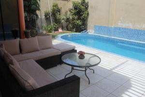sala de estar con sofá y mesa junto a la piscina en Hostal Shalom, en Pisco