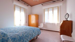 una camera con letto, cassettiera e finestre di Orchidea 2 Pineto Vacanza a Pineto