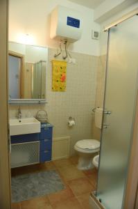 La salle de bains est pourvue de toilettes, d'un lavabo et d'un miroir. dans l'établissement Casa Vacanze Madrice, à Castellammare del Golfo