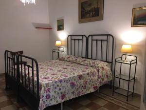 - une chambre avec un lit avec un couvre-lit floral et deux lampes dans l'établissement B&B Liberty, à Nardò