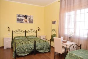 a bedroom with a bed and a table and a desk at B&B Vico Napoli Salento in Sannicola