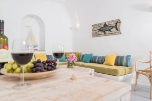 a table with a bowl of fruit and two glasses of wine at Calliope's Villa with jacuzzi in Pyrgos