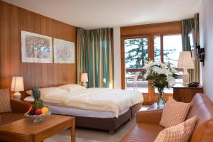 ein Schlafzimmer mit einem Bett und ein Wohnzimmer in der Unterkunft Aparthotel Helvetia in Crans-Montana