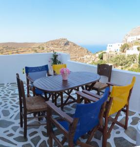 a table and chairs on a balcony with a view of the ocean at Evi's Studios in Tholária
