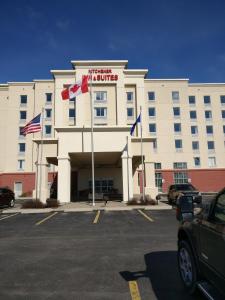 a large white building with a flag on top of it at Kitchener Inn & Suites in Kitchener