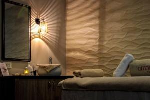 a cat sitting on the edge of a bed in a bathroom at Atlantic Hôtel & Spa in Les Sables-d'Olonne