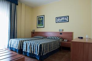 Habitación de hotel con 2 camas y mesa en Hotel Blue Ribbon, en Vercelli