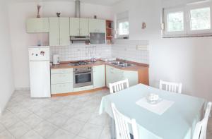 una cocina con electrodomésticos blancos y una mesa con sillas. en Apartment Marta, en Kali