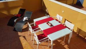 - une table et des chaises blanches avec une couverture rouge dans l'établissement Residencial Cotillo Playa, à El Cotillo
