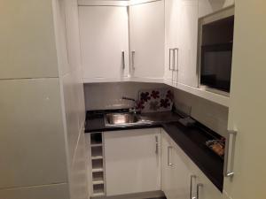 a kitchen with white cabinets and a sink and a microwave at The Liverpool Inn Hotel in Liverpool