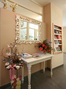 una mesa en una habitación con espejo y flores en Hotel Garni Golf en Ascona