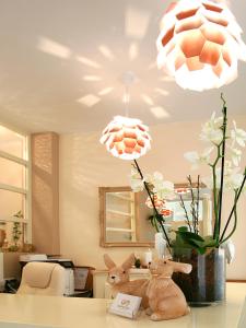 dois bichos de peluche sentados numa mesa com duas luzes em Hotel Garni Golf em Ascona