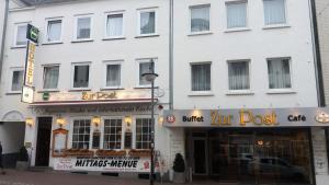 a large white building with two store fronts at Hotel zur Post Kleve in Kleve