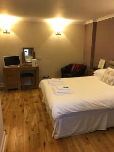 a hotel room with a large bed and a desk at The Crown Hotel in Peebles