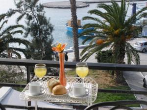a table with two glasses of orange juice and bread at Hotel Akti in Loutraki