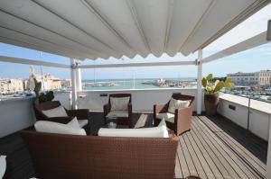 a balcony with chairs and tables and a view of the water at B&B Suite Home Trani in Trani