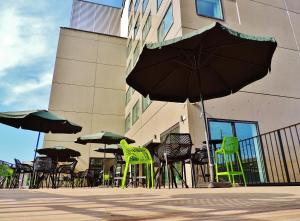 eine Gruppe von Stühlen und Sonnenschirmen vor einem Gebäude in der Unterkunft Campanile Metz Centre - Gare in Metz