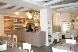 a restaurant with tables and white chairs and a counter at Hotel Daniela in Rimini
