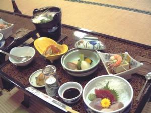 una mesa con tazones de comida encima en Oga Banseikaku, en Oga