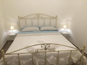un grande letto in una camera da letto con due lampade di La Conchiglia Tra i Due Mari a Trapani
