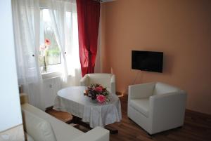 a living room with a table and two chairs and a television at Südwindappartement in Zwenkau