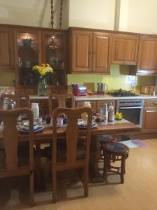 a kitchen with a wooden table with chairs and a tableasteryasteryasteryasteryastery at Badjao B&B in Edinburgh