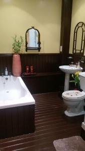 a bathroom with a tub and a toilet and a sink at Badjao B&B in Edinburgh