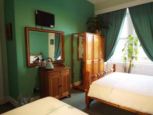 1 dormitorio con cama, tocador y espejo en Badjao B&B, en Edimburgo