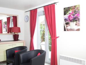 デ・ハーンにあるPleasant Holiday Home in De Haan by the Seaの赤いカーテン付きの窓が備わる客室です。