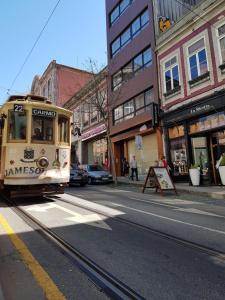 a trolley car driving down a city street at Passos Manuel by Innapartments in Porto