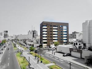 uma foto em preto e branco de uma rua da cidade com um edifício em Habitat Hotel em Lima