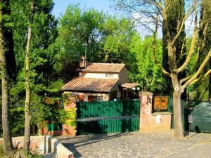 una casa con una recinzione verde e un cancello di Belvilla by OYO Casa Le Meridiane a Chiusdino