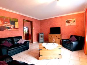 uma sala de estar com dois sofás e uma televisão em Cosy Holiday Home with Sauna Terrace Garden BBQ em Bütgenbach