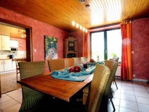 uma sala de jantar com uma mesa de madeira e cadeiras em Cosy Holiday Home with Sauna Terrace Garden BBQ em Bütgenbach