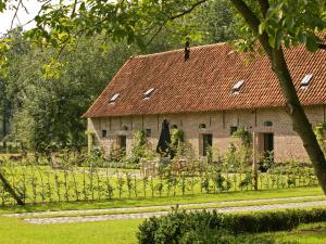 ein großes Backsteingebäude mit rotem Dach in der Unterkunft Rural holiday home in former stables in Beernem