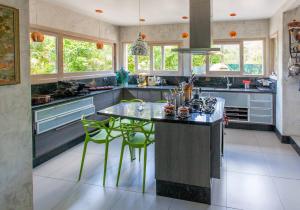 a kitchen with a island with green chairs at Casa Tucano in Florianópolis