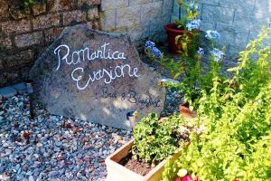 a garden with a rock and some plants and flowers at Bed and Breakfast Romantica Evasione in Sutri