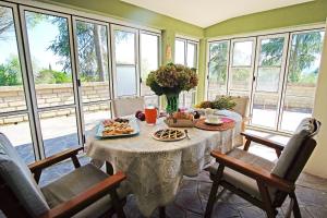 een tafel met eten in een kamer met ramen bij Bed and Breakfast Romantica Evasione in Sutri