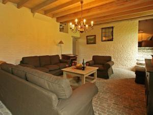 Sala de estar con 2 sofás y mesa en Rural holiday home in former stables en Beernem
