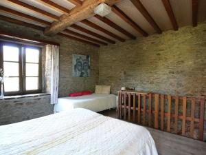 a bedroom with two beds and a brick wall at Attractive Cottage in Baillamont with Terrace in Bièvre