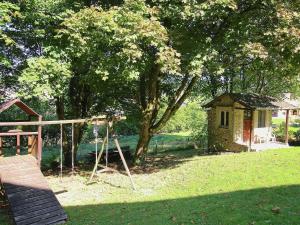 a swing set in a yard next to a house at Attractive Cottage in Baillamont with Terrace in Bièvre