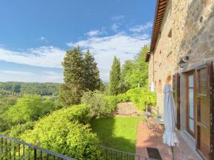 a balcony with an umbrella and a garden at Stunning Holiday Home in Figline Valdarno with Barbecue in Figline Valdarno
