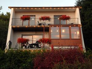 een huis met een balkon met rode bloemen erop bij Modish Holiday Home in Waimes with Sauna in Waimes