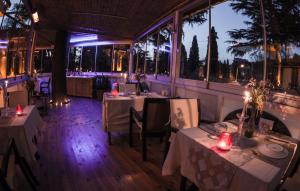 un restaurante con mesas con manteles blancos y velas en Nizam Butik Otel Büyükada, en Büyükada